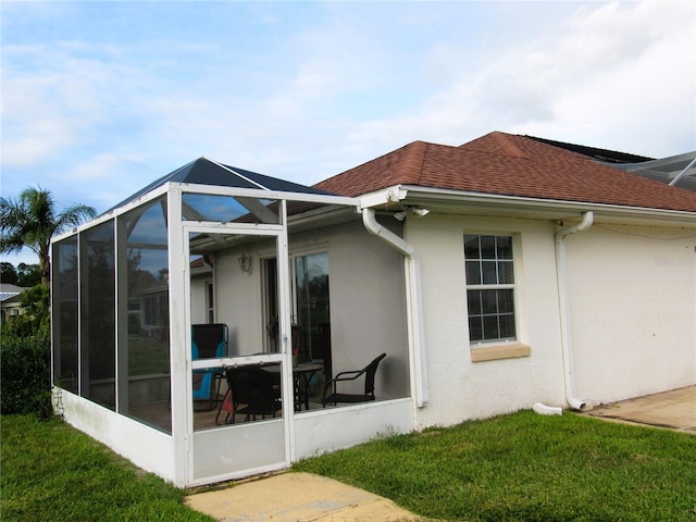 view of property exterior with a yard, a sunroom, and a lanai