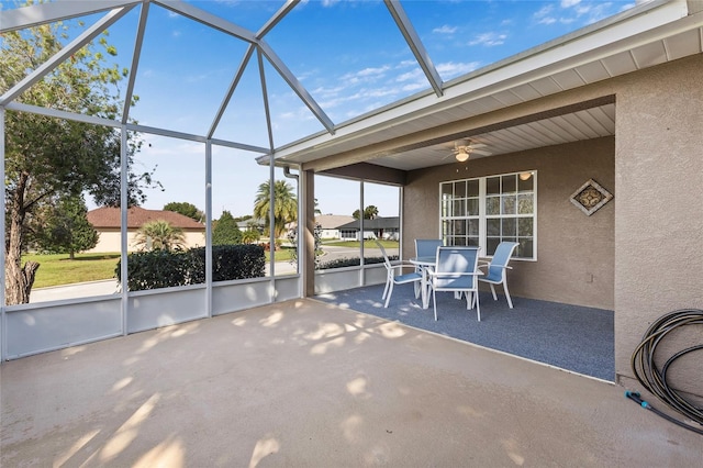 view of patio featuring ceiling fan and glass enclosure