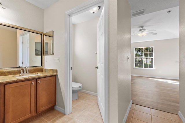 bathroom featuring tile patterned flooring, vanity, toilet, and ceiling fan