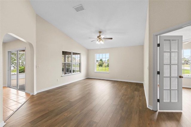 unfurnished room featuring lofted ceiling, ceiling fan, dark hardwood / wood-style floors, and a healthy amount of sunlight