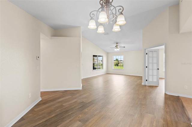 empty room with ceiling fan with notable chandelier, lofted ceiling, and hardwood / wood-style floors