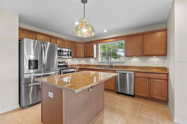 kitchen with appliances with stainless steel finishes, pendant lighting, sink, a center island, and light stone countertops