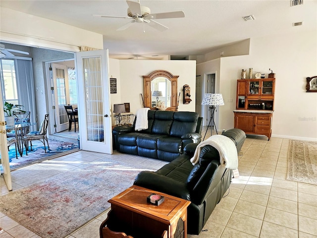 tiled living room featuring french doors and ceiling fan