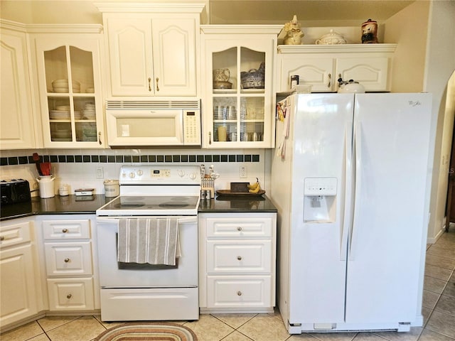 kitchen featuring white appliances, tasteful backsplash, light tile patterned floors, and white cabinets