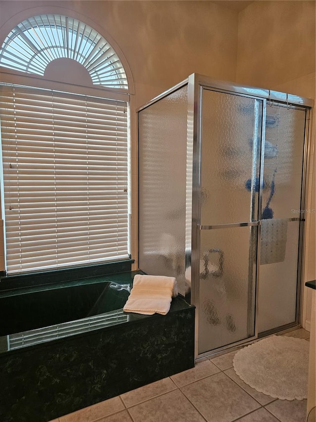 bathroom featuring a healthy amount of sunlight, independent shower and bath, and tile patterned floors