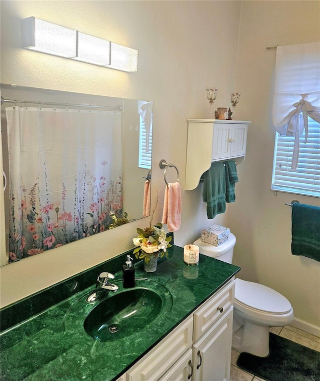 bathroom featuring vanity, toilet, plenty of natural light, and tile patterned flooring