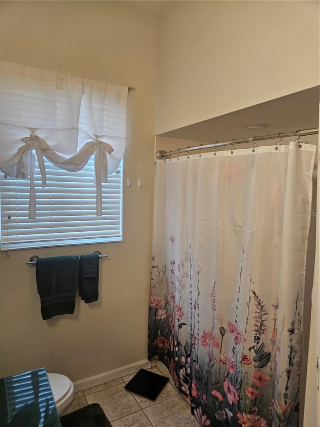 bathroom with tile patterned floors, toilet, and walk in shower