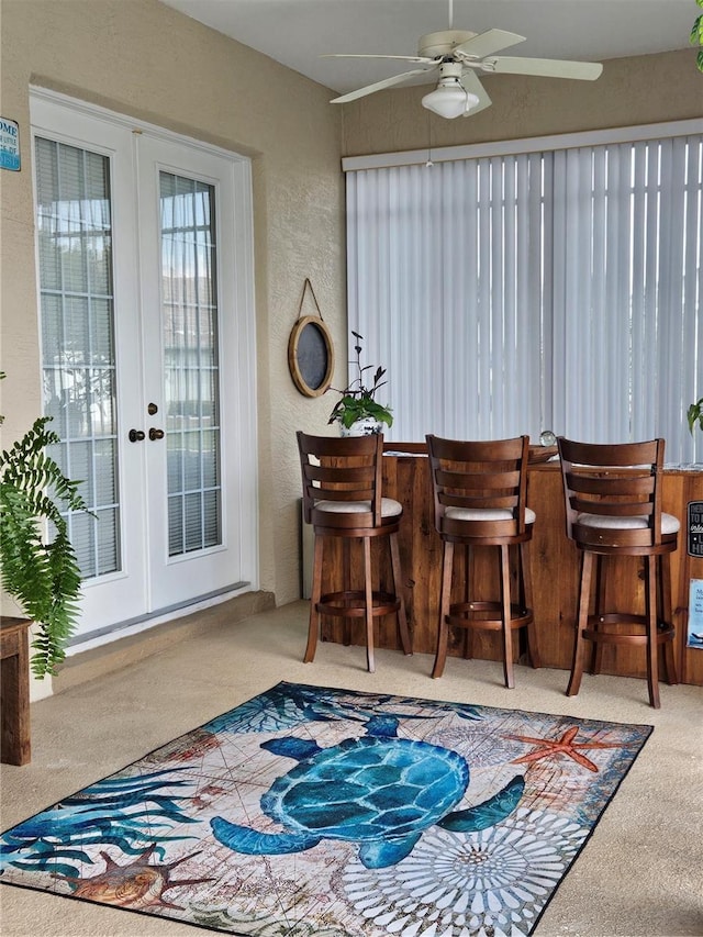 bar featuring french doors, carpet floors, and ceiling fan