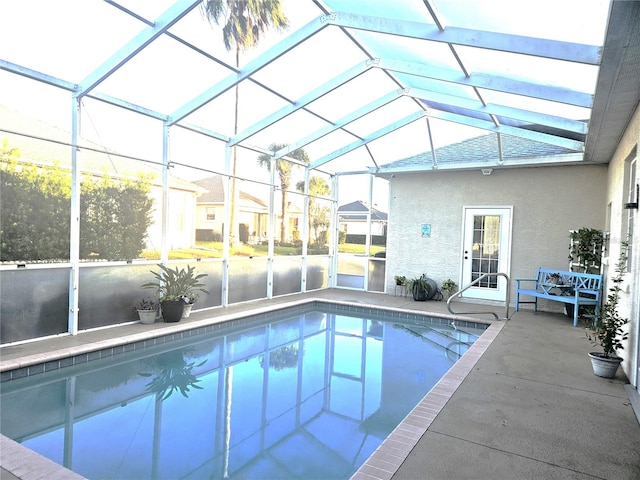 view of swimming pool with a patio area and glass enclosure