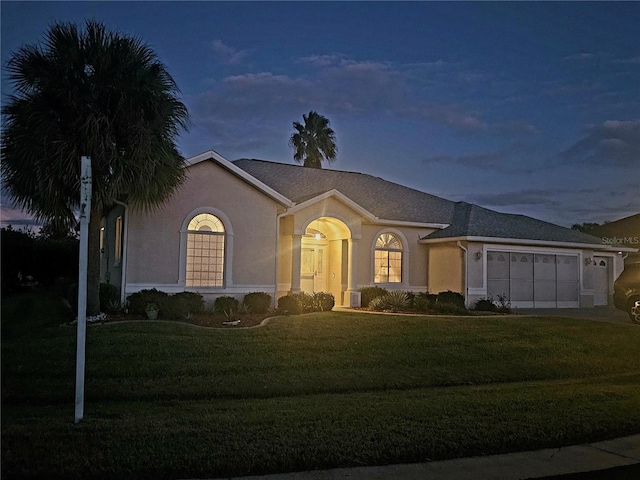 view of front of house featuring a garage and a lawn