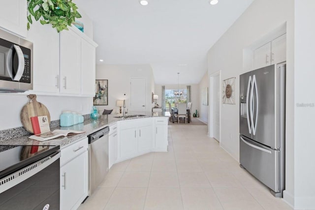 kitchen featuring sink, white cabinets, appliances with stainless steel finishes, and kitchen peninsula