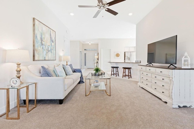 living room featuring ceiling fan, vaulted ceiling, and light carpet