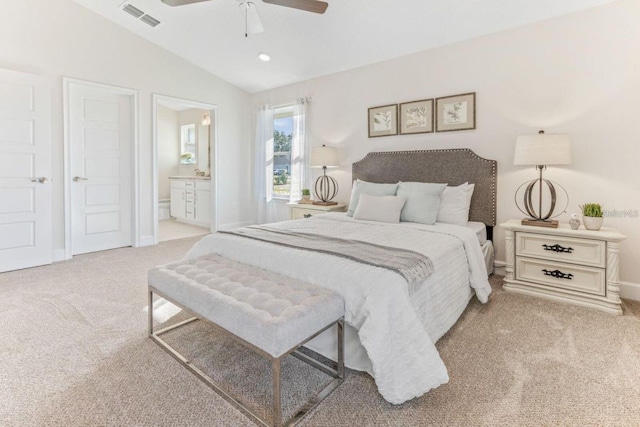 bedroom with ceiling fan, light colored carpet, lofted ceiling, and ensuite bath