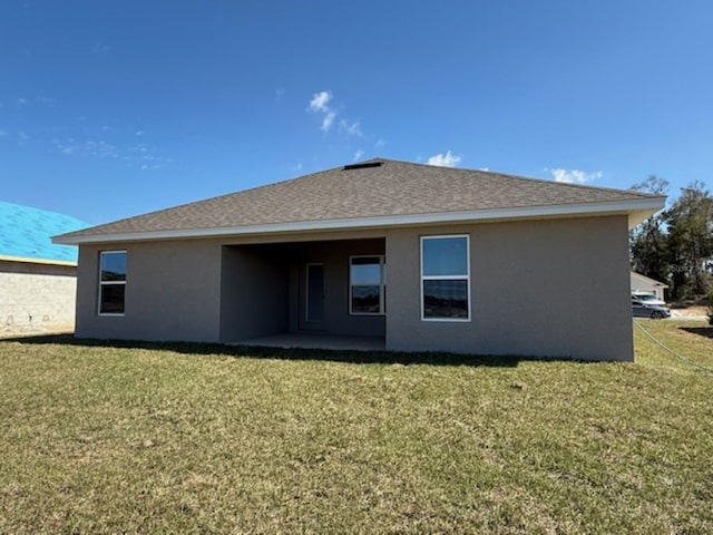 rear view of house featuring a yard