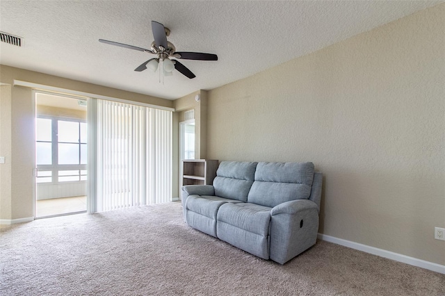 sitting room with carpet, ceiling fan, and a textured ceiling