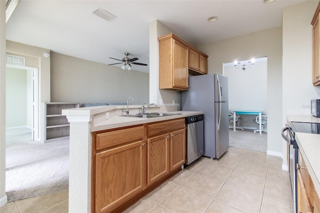 kitchen featuring kitchen peninsula, light carpet, stainless steel appliances, ceiling fan, and sink