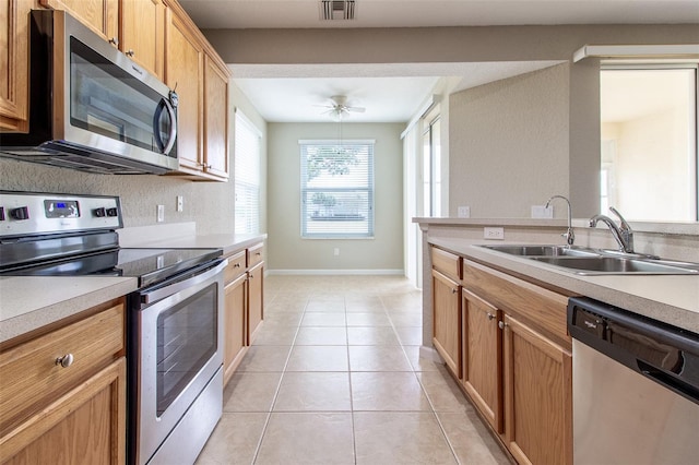 kitchen with light tile patterned floors, stainless steel appliances, ceiling fan, and sink