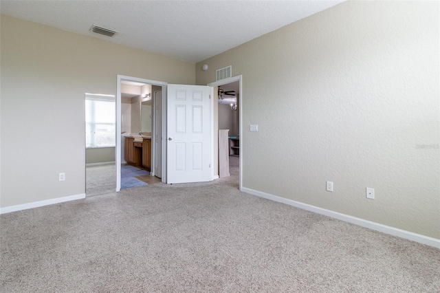 unfurnished bedroom with light carpet and ensuite bath