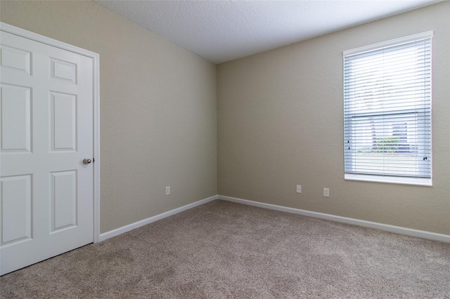 unfurnished room with light carpet and a textured ceiling