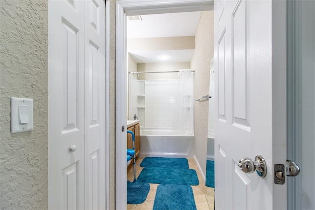 bathroom featuring tile patterned flooring, shower / bath combination with curtain, and a textured ceiling