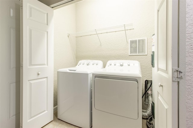 laundry area with light tile patterned floors and independent washer and dryer