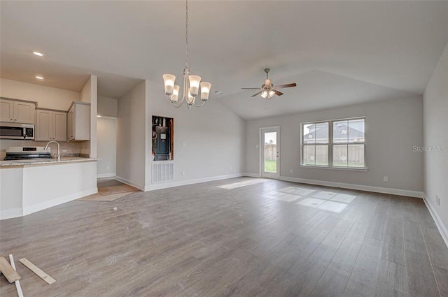 unfurnished living room with light wood-type flooring, ceiling fan with notable chandelier, and lofted ceiling