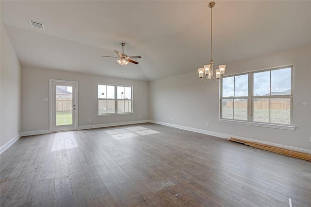 spare room featuring lofted ceiling, hardwood / wood-style floors, and ceiling fan with notable chandelier