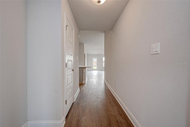 hallway with dark hardwood / wood-style flooring