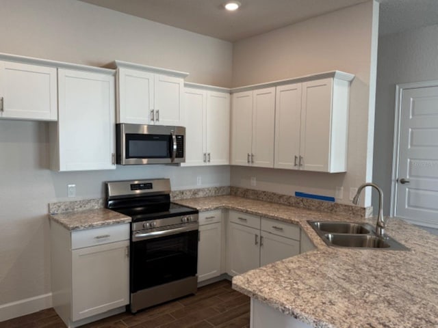 kitchen featuring sink, appliances with stainless steel finishes, white cabinetry, and light stone countertops