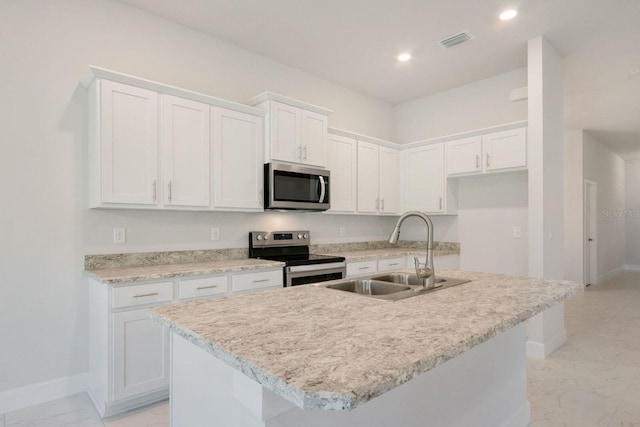 kitchen with white cabinetry, stainless steel appliances, sink, and a kitchen island with sink