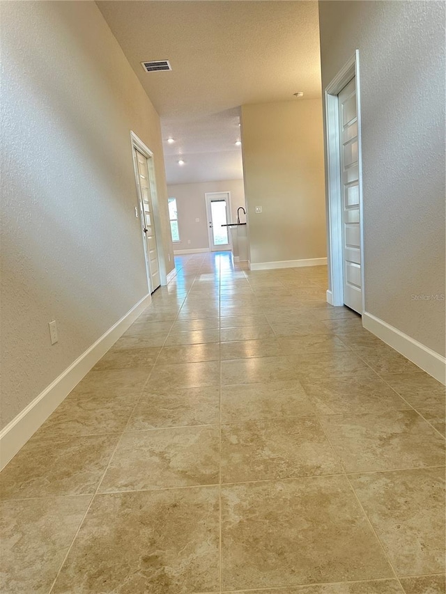 3127 NE 45th Ave, Ocala, FL 34470 - hallway featuring light tile patterned floors, baseboards, a textured wall, and visible vents
