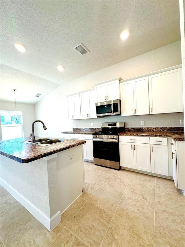 3127 NE 45th Ave, Ocala, FL 34470 - kitchen with visible vents, a sink, dark countertops, a textured ceiling, and stainless steel appliances