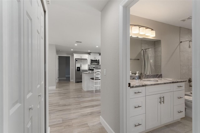 bathroom with vanity, toilet, wood-type flooring, and a shower with curtain