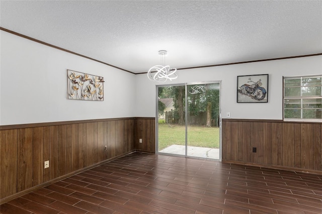 unfurnished room with wooden walls, a textured ceiling, and dark hardwood / wood-style flooring