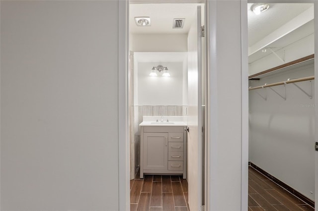 bathroom with vanity, wood-type flooring, and a textured ceiling