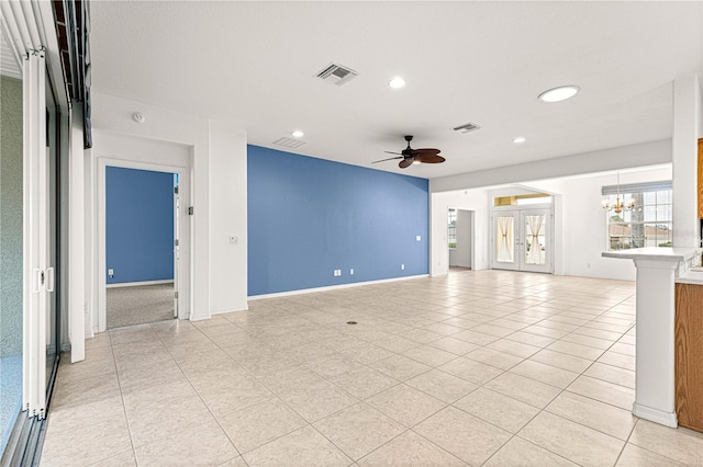 unfurnished living room with ceiling fan with notable chandelier, light tile patterned floors, and visible vents