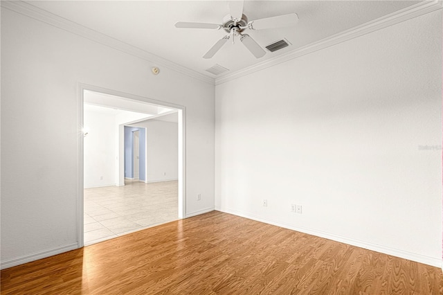 empty room with ceiling fan, wood finished floors, visible vents, baseboards, and ornamental molding