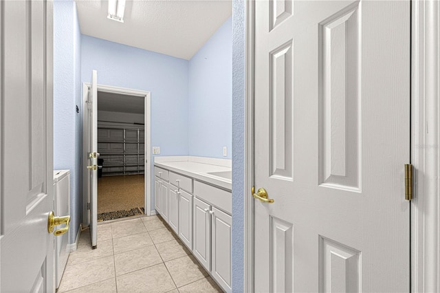 bathroom with a textured ceiling, vanity, and tile patterned floors