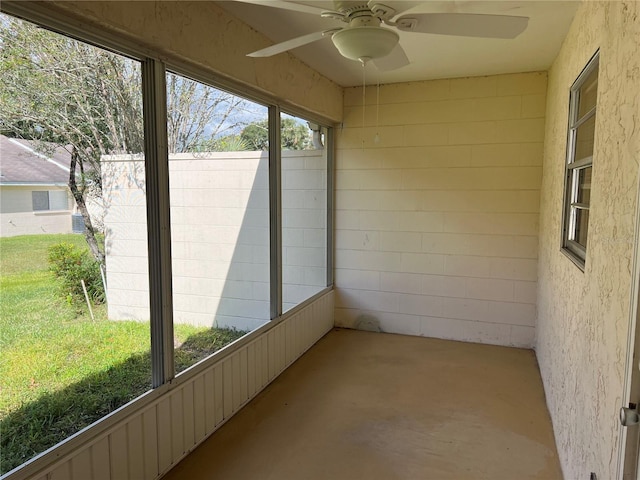 unfurnished sunroom with ceiling fan