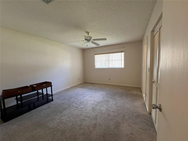 empty room with light carpet, a textured ceiling, and ceiling fan