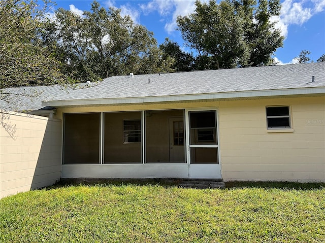 back of property featuring a yard and a sunroom