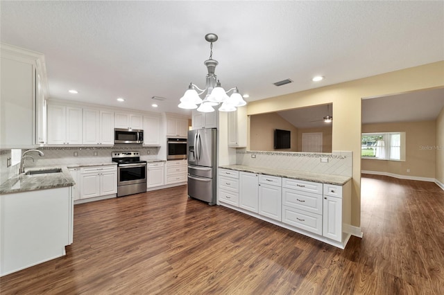 kitchen featuring stainless steel appliances, dark hardwood / wood-style floors, hanging light fixtures, sink, and white cabinets