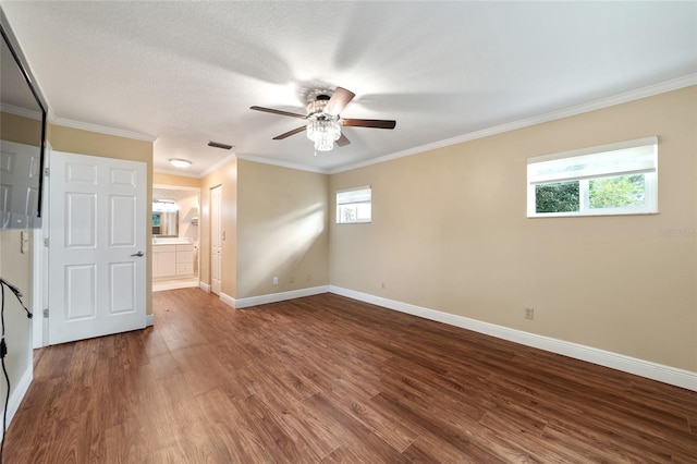 empty room with plenty of natural light, wood-type flooring, and crown molding