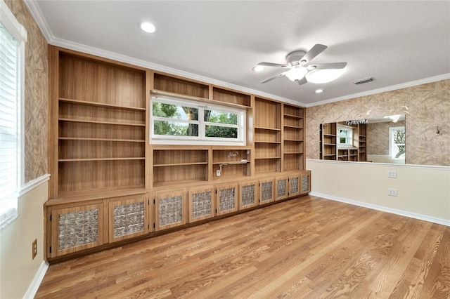 unfurnished living room featuring hardwood / wood-style flooring, ceiling fan, and crown molding