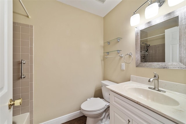 full bathroom featuring vanity, tiled shower / bath, and toilet