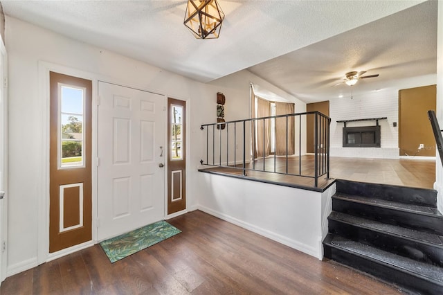 foyer with a fireplace, hardwood / wood-style floors, a textured ceiling, and plenty of natural light