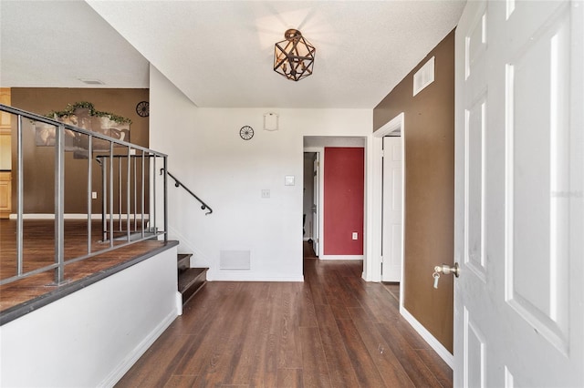 entrance foyer featuring a textured ceiling and dark hardwood / wood-style flooring