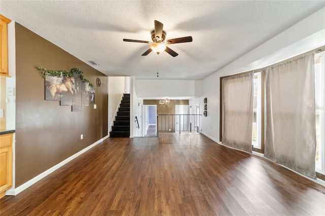 unfurnished living room featuring a textured ceiling, dark hardwood / wood-style floors, and ceiling fan with notable chandelier