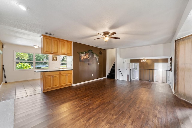 kitchen with a textured ceiling, kitchen peninsula, and hardwood / wood-style floors