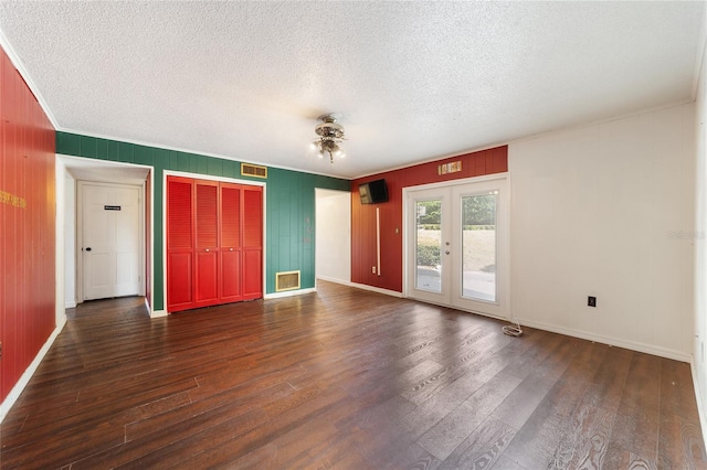 interior space with dark wood-type flooring, a textured ceiling, and french doors